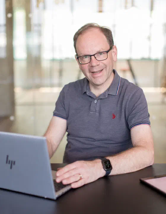 Wolfgang Auer in einer Arbeitssituation mit Laptop