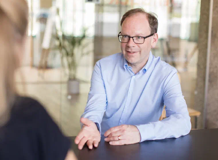 Wolfgang Auer in einer Arbeitssituation mit Gesprächspartnerin